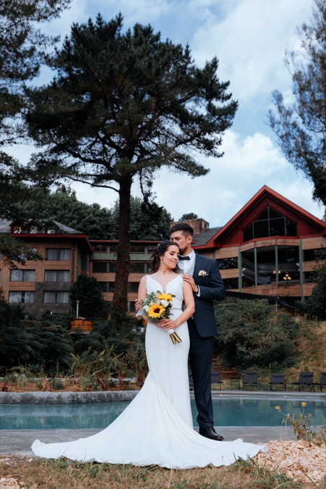 Novios frente a un lodge junto a la piscina